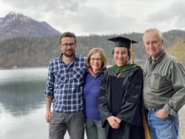 Dr. Southworth and family in front of a lake, daughter in graduation robes