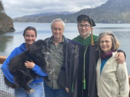 Dr. Southworth and family in front of a lake, son in graduation robes